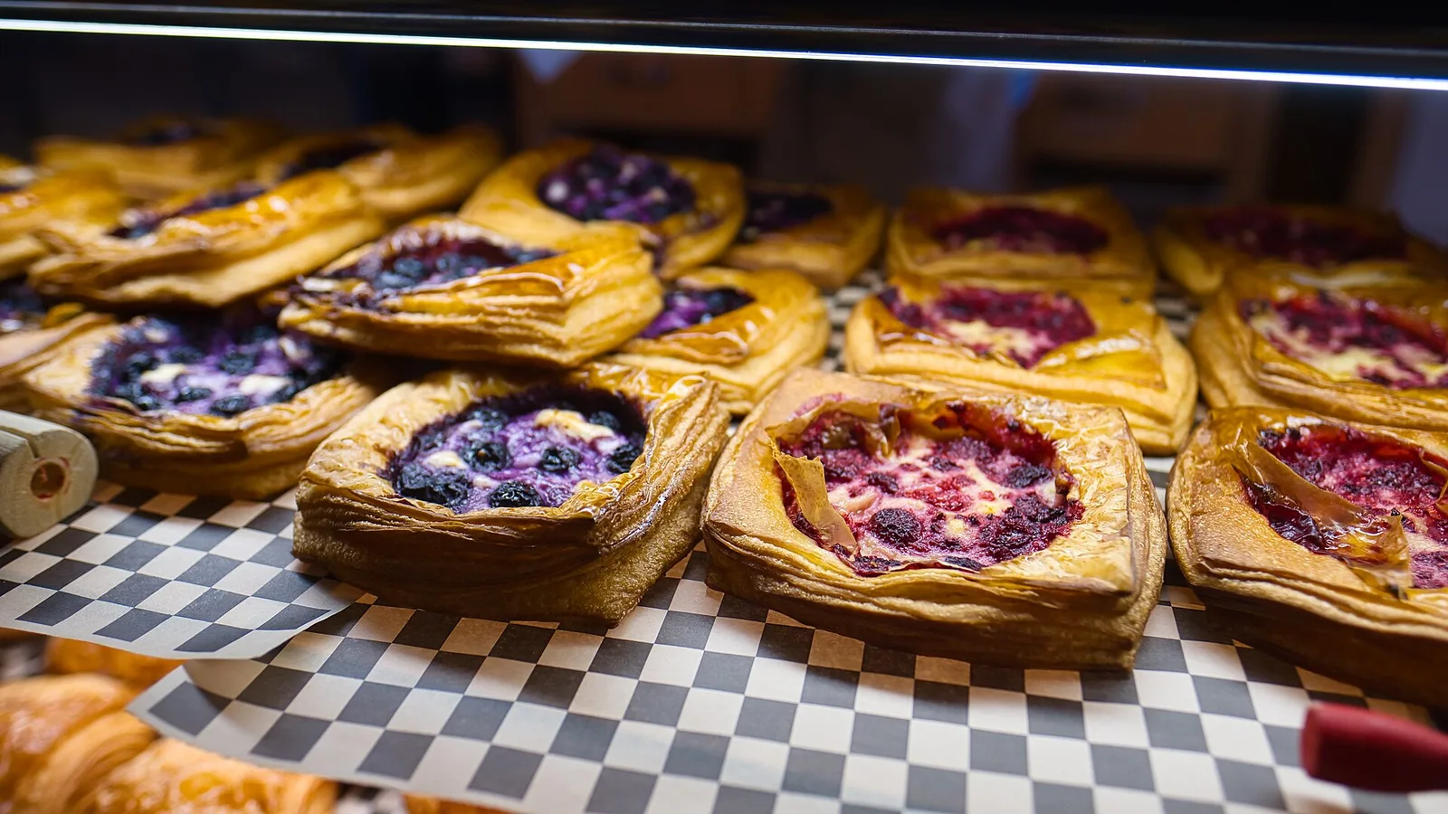 Fruit-filled pastries in a bakery display case.