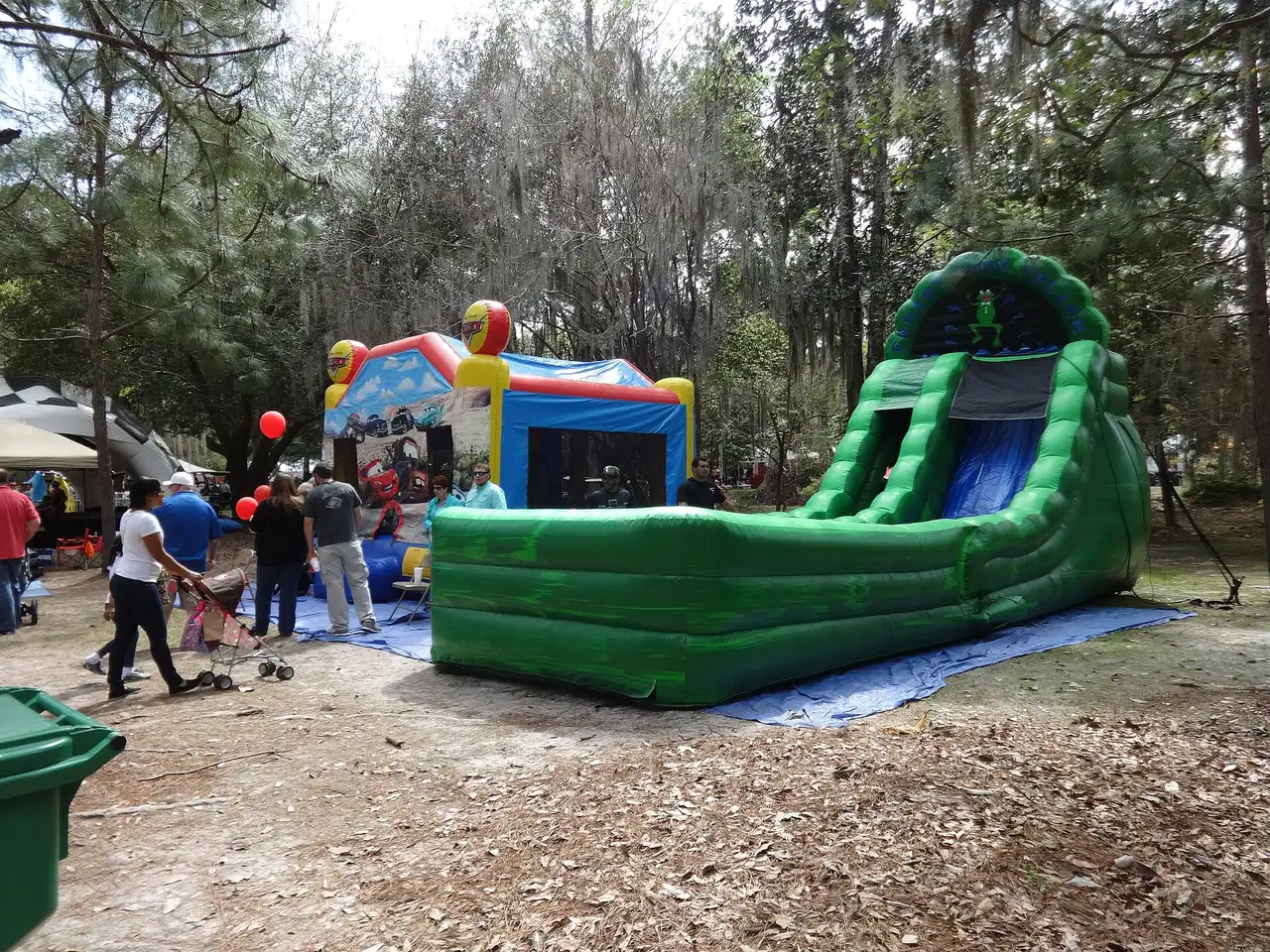 An inflatable bounce house and water slide set up for families at a park festival in Valdosta, Ga.