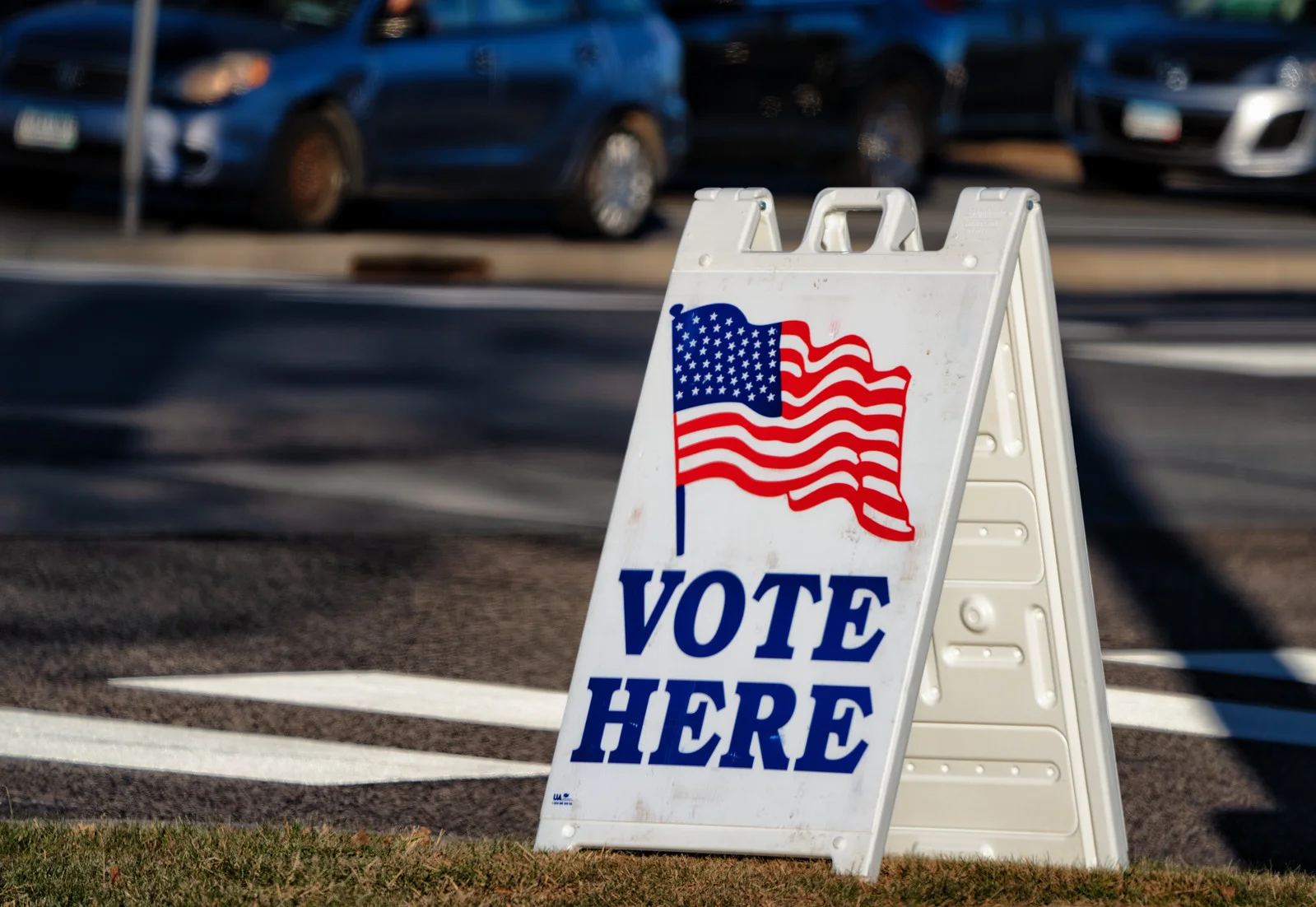 A Vote Here sign with an American flag outside a polling place on Election Day