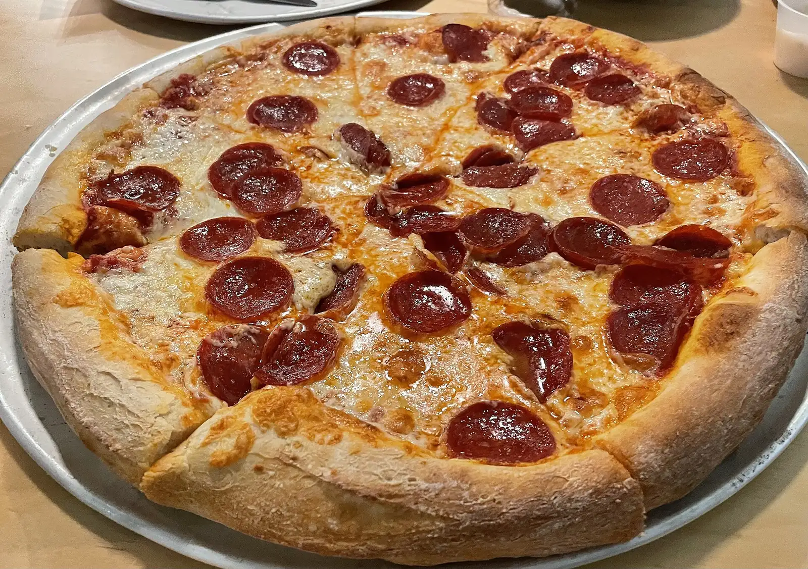A pepperoni pizza on a metal pan.